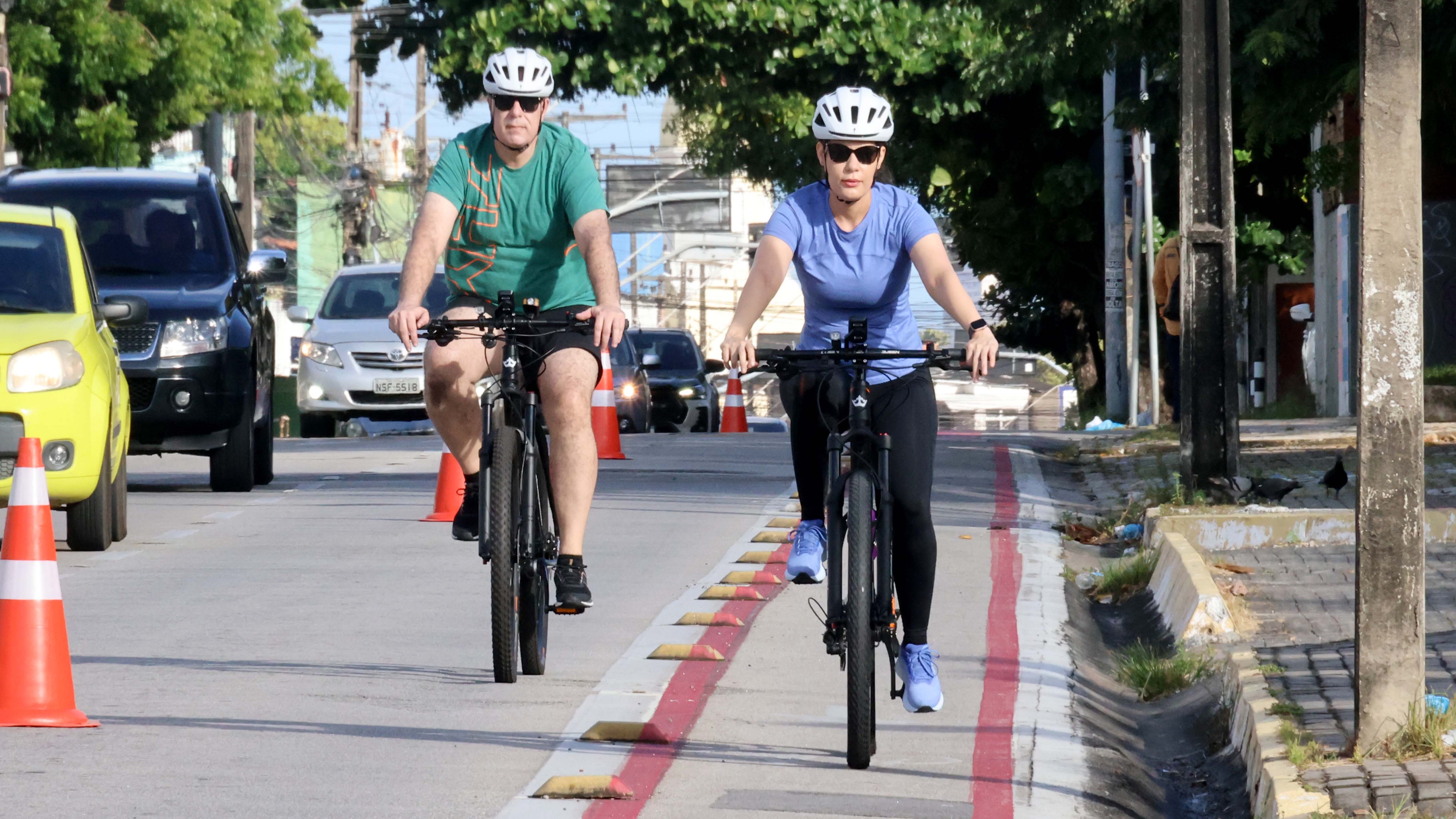 duas pessoas andando de bicicleta numa ciclofaixa